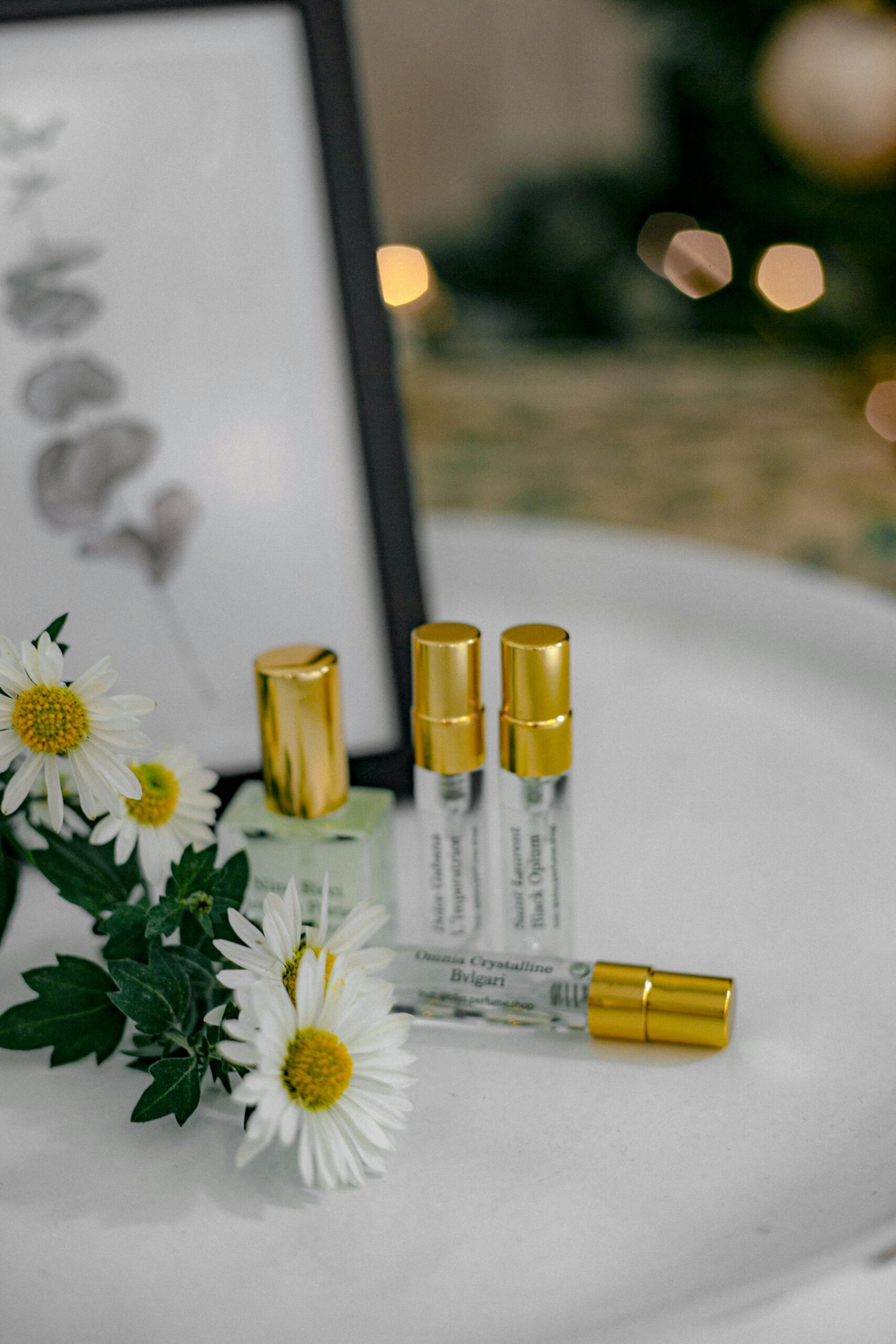 Une composition élégante de flacons de parfum avec des marguerites et des bouchons dorés, parfaite pour les concepts de beauté.